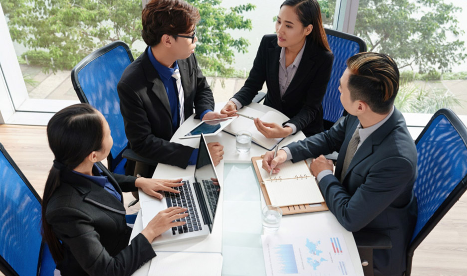 people sitting around table, engaged in a conversation about their needs and requirements