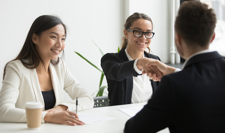 Partnership symbolized by a handshake after discussing needs