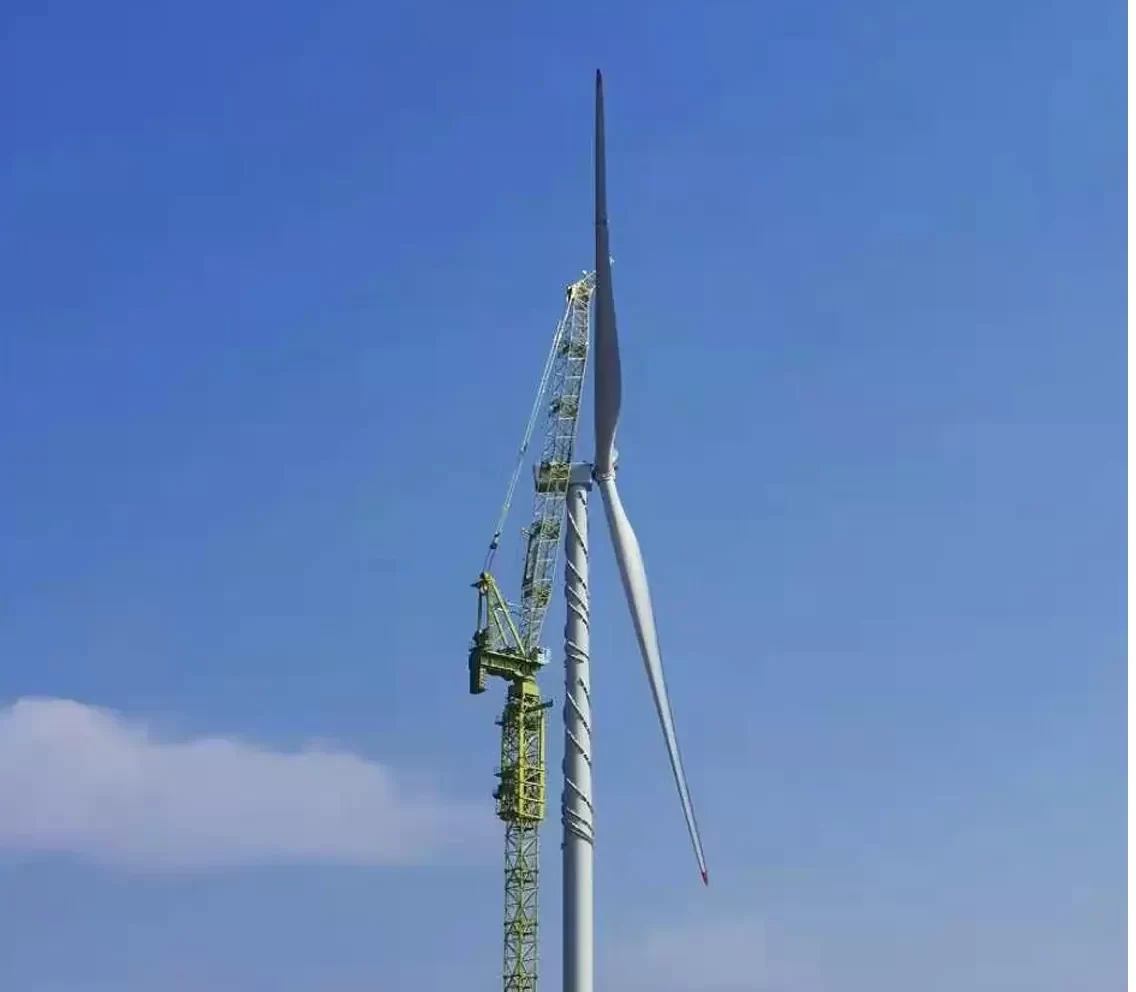 Wind turbine tower crane lifting a turbine equipment blade